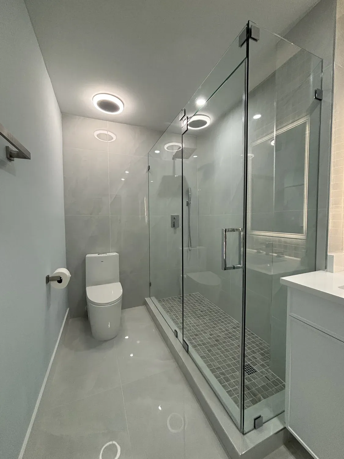 Frameless glass steam shower with mosaic tile floor