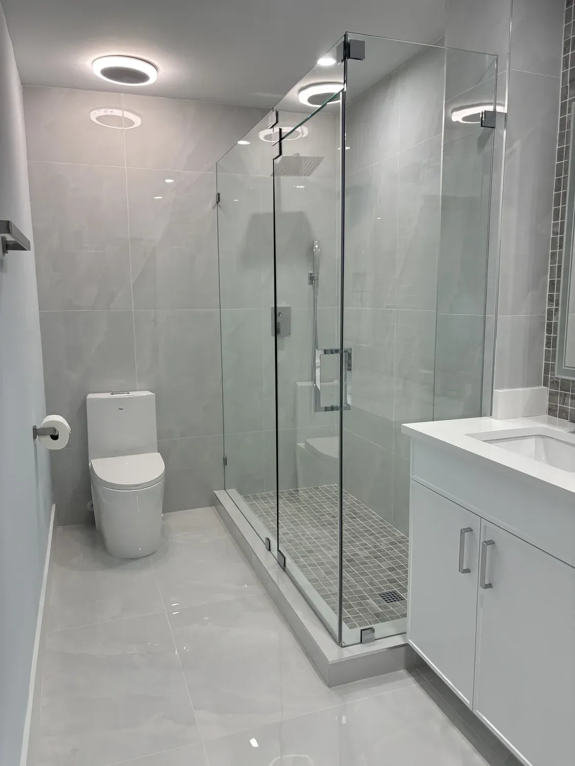 Marble-tile bathroom with frameless glass shower enclosure